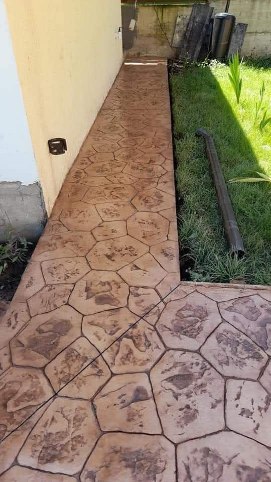 Pasillo exterior con acabado de piedra impresa y resistente
