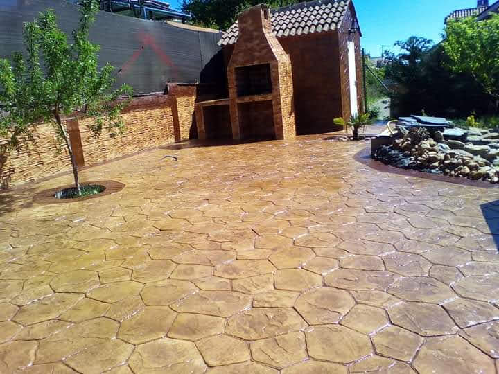 Patio exterior pavimentado con hormigón impreso en tonos tierra en Valencia