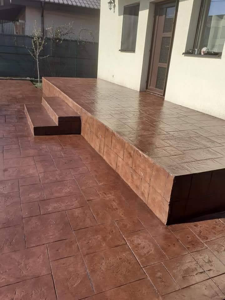Terraza y escalones revestidos de hormigón impreso en tonos rojizos